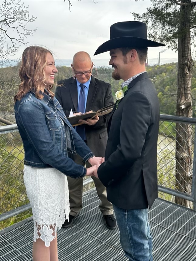 Kevin officiating outdoor ceremony on elevated platform with bride and groom