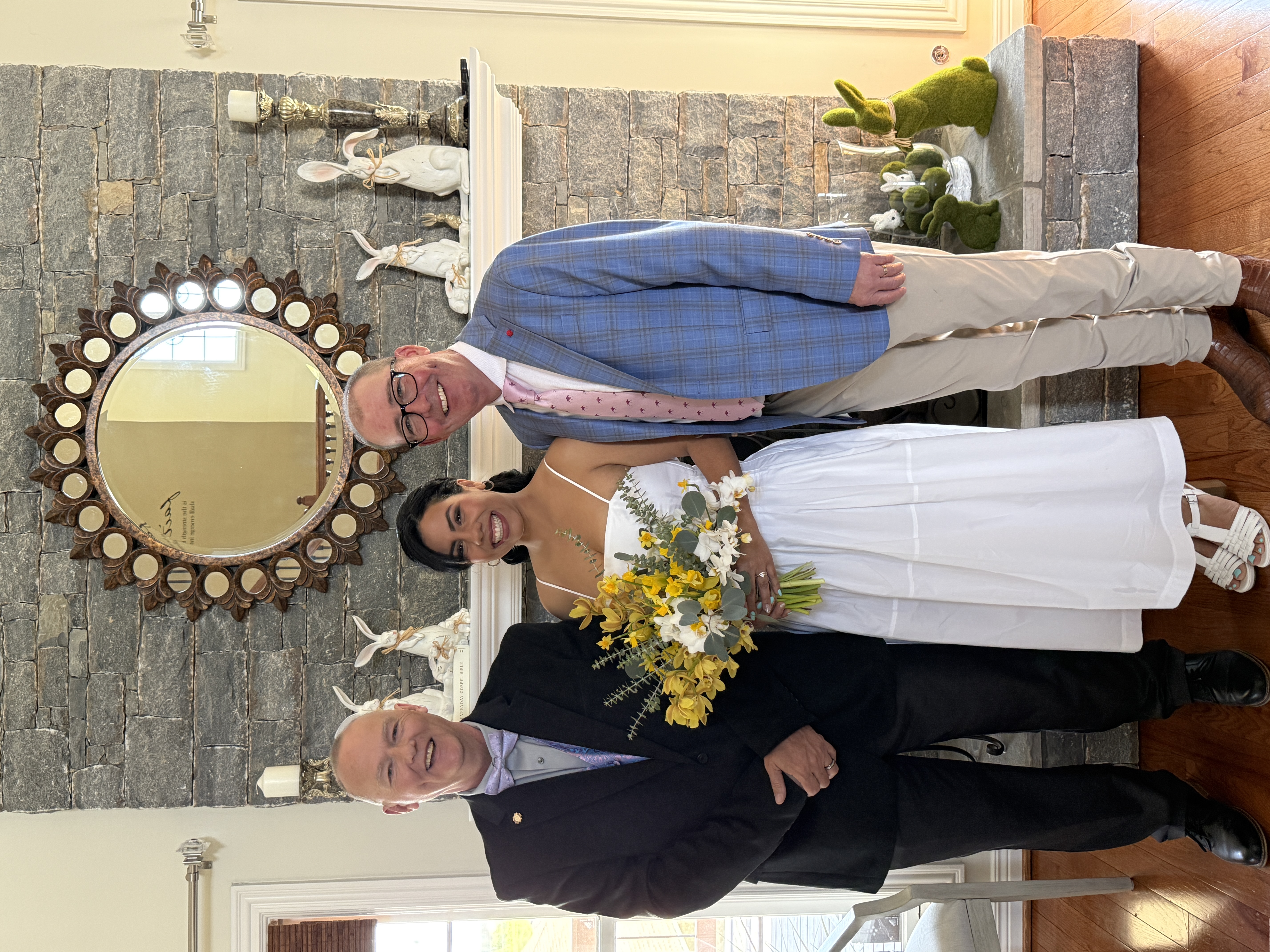 Kevin with couple indoors after ceremony with yellow bouquet